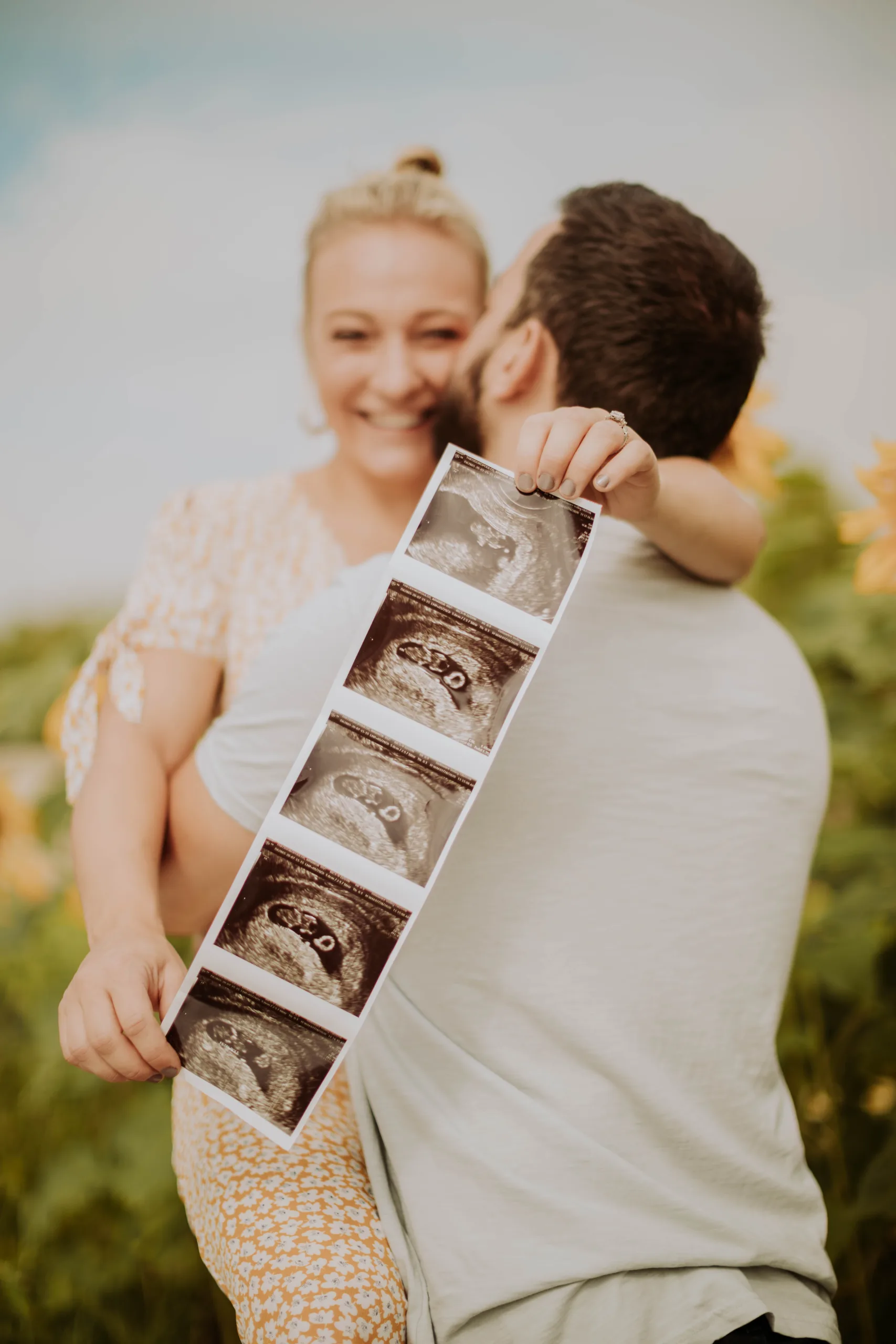 Pareja mostrando ultrasonidos; consulta y tratamientos de fertilidad y reproducción asistida.